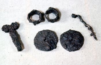 Dette er en beltehake, en draktnål, to ringer og to plater av jern fra Grimstad i Aust-Agder. Les mer om den første jernproduksjonen i Norge. Foto: Elizabeth Skjelsvik/Kulturhistorisk museum, UiO/CC BY-NC 3.0