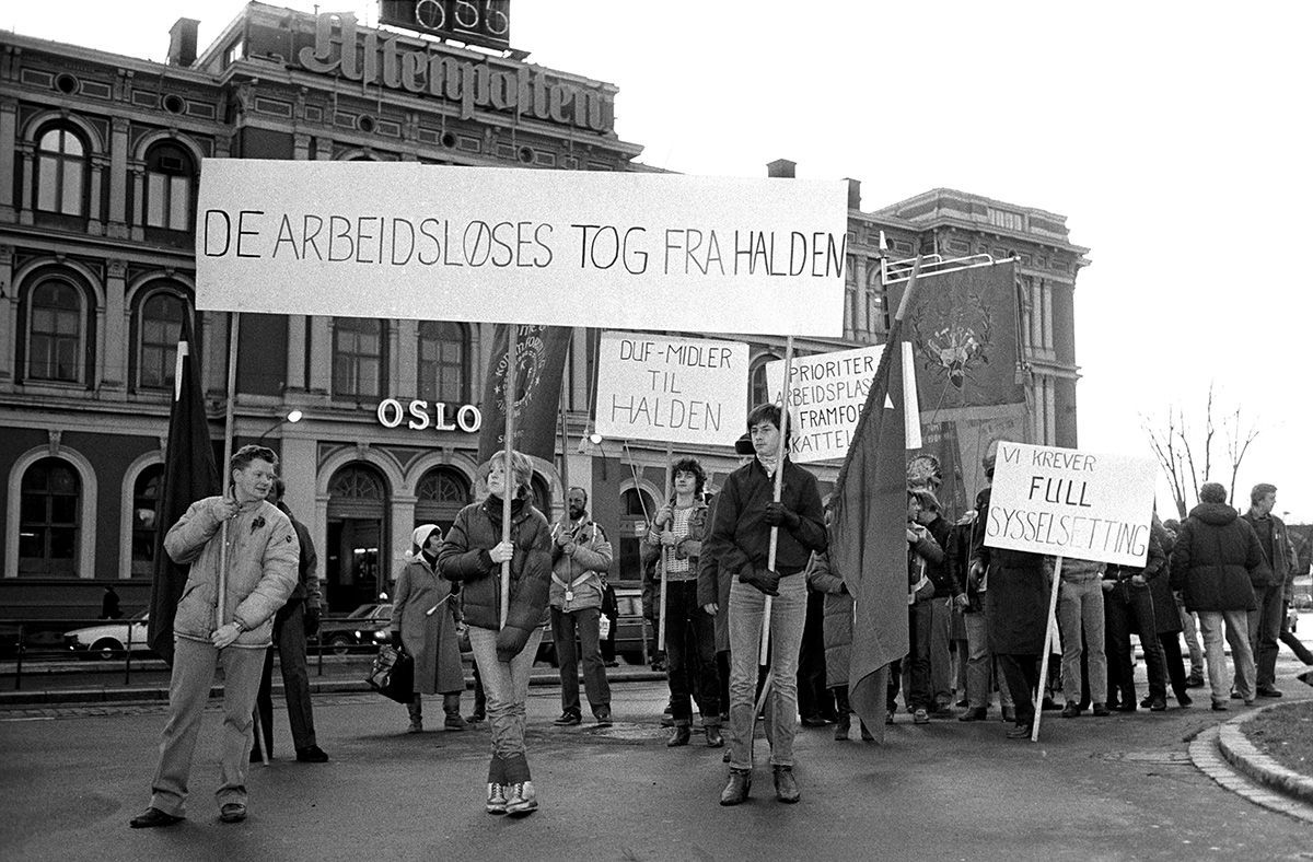 Fotografi som viser tog av arbeidsløse, med plakat, tekst: "De arbeidsløses tog fra Halden"