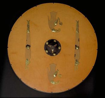 Dette skjoldet som vart funne i Vendel i Uppland i Sverige, har ein stor likskap til eit skjold frå Sutton Hoo i Suffolk i England. Les om kva det kan fortelje oss om personleg kontakt mellom kongeslekter i merovingertida . Foto: Statens historiska museum/ CC BY 2.5