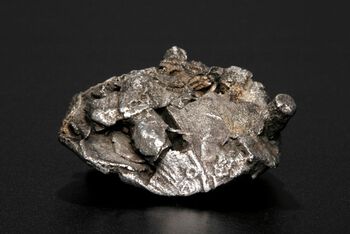 En sølvklump fra vikingtidsbyen Kaupang med arabiske mynter, armbåndsfragmenter og annet betalingssølv som var i ferd med å bli smeltet om. Kanskje det skulle bli til en ny spenne? Les mer om hvordan rikdom sirkulerte i vikingtiden . Foto: Eirik Irgens Johnsen/Kul­tur­his­torisk museum, UiO/ CC BY-SA 4.0