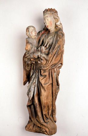 Jomfru Maria med Jesusbarnet fra gotisk periode. Det er en større menneskelighet i skulpturen. Les mer om helgenskulpturene i kirkerommet . Eikeskulptur med maling som er påført etter at den er laget. Jesusbarnet holder en globus i hånden. Fra Misvær, Skjerstad i Nordland. Tromsø museum.&amp;#160; CC BY-NC-ND 3.0