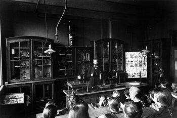 Naturfag var også for jenter, det viser dette bildet fra fysikksalen på Kalvskindet skole i Trondheim rundt 1900. Legg merke til de velordnede bokstablene. Her er orden og disiplin både ideal og praksis. Les mer om utviklingen av det norske skolesystemet på 1800-tallet .&amp;#160;Foto: E. Olsen/Trondheim byarkiv/ CC BY 2.0