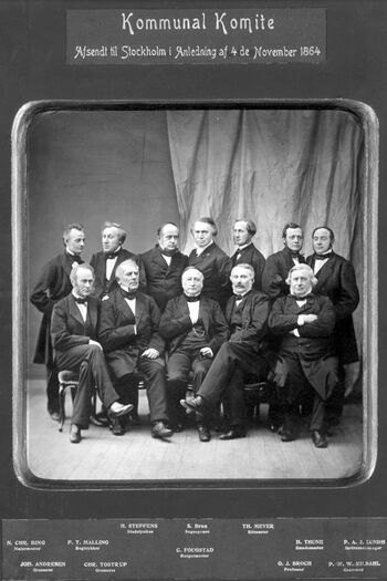 Dette fotografiet viser en «Kommunal Komite. Afsendt til Stockholm i anledning 4de November 1864». Bildet ble sendt fra Christiania i anledning Grunnlovens 50-årsjubileum. Les mer om&amp;#160; det lokale selvstyret i&amp;#160;Norge på 1800-tallet .&amp;#160;Foto: Oslo byarkiv/ CC BY-SA 3.0