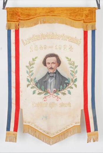 Fanen til Larvik arbeiderforening, stiftet 1849, med portrett av Marcus Thrane. På baksiden står det skrevet: «Kun retfærdighet fordrer vi». Les mer om arbeiderforeningenes kamp for&amp;#160;sosiale reformer og stemmerett, og rettsakene som fulgte .&amp;#160;Foto: Vestfoldarkivet/ CC BY-SA
