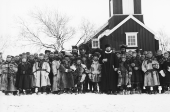 Frå myndigheitshald var det brei semje om at den tradisjonelle samiske religionen måtte utryddast, men blandt kyrkjas menn var det delte meiningar om den sterke vektlegginga av bruken av norsk språk overfor samar og kvener frå myndigheitenes side. Nokre meinte at Bibelens bodskap ikkje kom klart nok fram når det vart forkynt på eit framandt språk. Biletet er teke utanfor kyrkja i Kautokeino etter gudsteneste i 1882/1883. Les meir om fornorskingspolitikken i nord . Foto: Sophus Tromholt/Universitetsbiblioteket i Bergen/ CC BY-SA