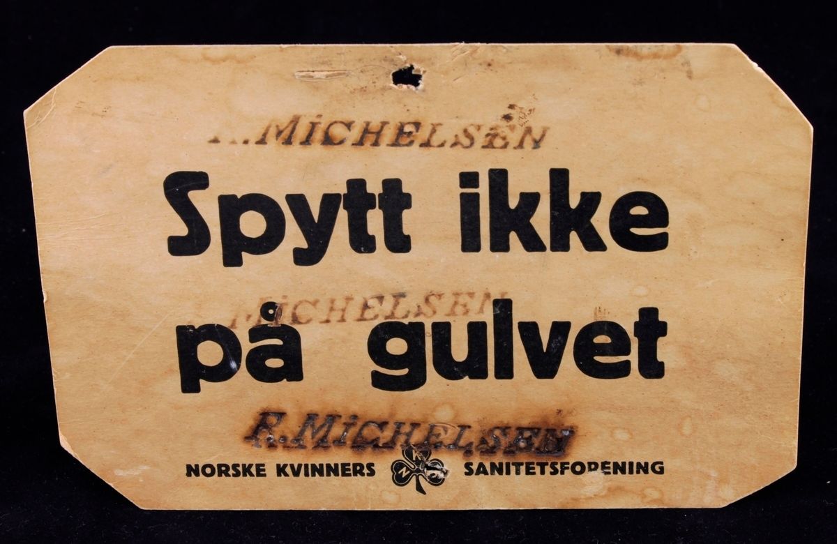 Skilt med tekst: "Spytt ikke på gulvet. Norske kvinners sanitetsforening"