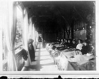 Kvinnelige pasienter på veranda, trolig på et sanatorium. Bildet er antakeligvis tatt mellom 1885 og 1918. Les mer om kampen mot tuberkulose og forsøkene på å forbedre hygienen i det norske samfunnet i mellomkrigstiden . Foto: Severin Worm-Petersen/Norsk Teknisk Museum