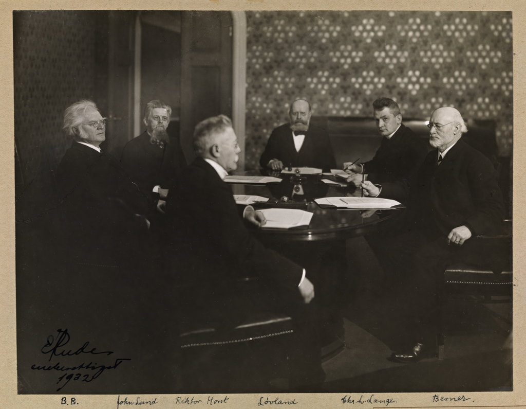 Komitémøte med seks personer sittende rundt et bord