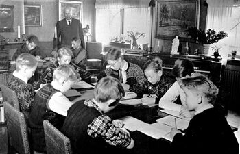 Dersom okkupanten rekvirerte skolebygningen, kunne undervisningen foregå på andre måter. Her undervises elever fra en skoleklasse i Oslo i et privat hjem. Bildet er tatt i 1943. Nazismen fikk ikke innpass i den norske skolen under krigen. Les mer om holdningskampen mot nazismen . Foto: NTB scanpix