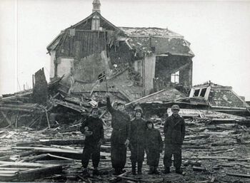 Fem gutter forran ruinene etter Vadsø skole. Bildet er antakelig tatt like etter tyskerne trakk seg ut av Øst-Finnmark i oktober 1944. Vadsø ble utsatt for omfattende bombing fra sovjetisk side under andre verdenskrig og gjenreisningen av byen bød på store utfordringer . Foto: ukjent/Riksarkivet