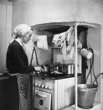 Husmor ved komfyren. Bildet er tatt i&amp;#160;1957. Les mer om tiårene da over halvparten av norske kvinner var husmødre . Foto: Byhistorisk samling/Oslo Museum/ CC BY-SA