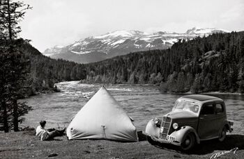 Bilen ble utover 1950-tallet et svært vanlig syn i gatebildet i Norge. Den ble i første omgang et symbol på frihet, velstand og uavhengiget . Her har den muliggjort en feritur til Valdres i 1960. Foto: Normann/Normann kunstforlag AS/ CC BY
