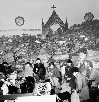 Kirkens Nødhjelp ble&amp;#160;opprettet i 1947 under Menighetspleiernes Landsforbund, og fikk i 1953 status som selvstendig organisasjon. Bildet er fra høsten 1947 og viser en av Kirkens Nødhjelps første innsamlingsaksjoner. I pakkene ligger det hovedsaklig klær som skal til nødlidende mennesker i Tyskland. Les mer om kirken i etterkrigsårene . Foto: ukjent/Kirkens Nødhjelp