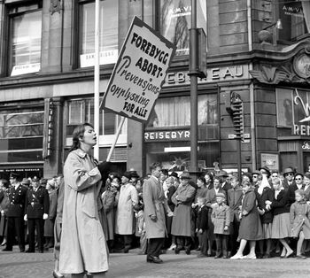Kvinne med prevensjonsparole i 1. mai-tog på Karl Johans gate i 1958. Les mer om prevensjonsrevolusjonen i Norge . Foto: Jan Stage/NTB Scanpix&amp;#160;