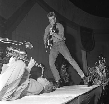 Ved begynnelsen av den kalde krigen ble USA gjerne assosiert med populærkultur. I løpet av denne perioden vant amerikanske tegneserier, filmer og musikk innpass i norsk kulturliv. Her er Odd «Smiling Tommy» Gisløy, som var blant konkurrentene i det første nordiske rockemesterskapet, holdt i Jordal amfi i Oslo i 1958. Reaksjonene på amerikansk populærkultur i Norge var blandete - noe som bidro til at amerikanske myndigheter brukte ressurser på å formidle at USA også hadde en høykultur som liknet tradisjonell europeisk høykultur. Les mer om USA i norsk opinion ved begynnelsen av den kalde krigen . Foto: Arbeiderbladet/Arbeiderbevegelsens arkiv og bibliotek/ CC BY-NC-ND 3.0 NO
