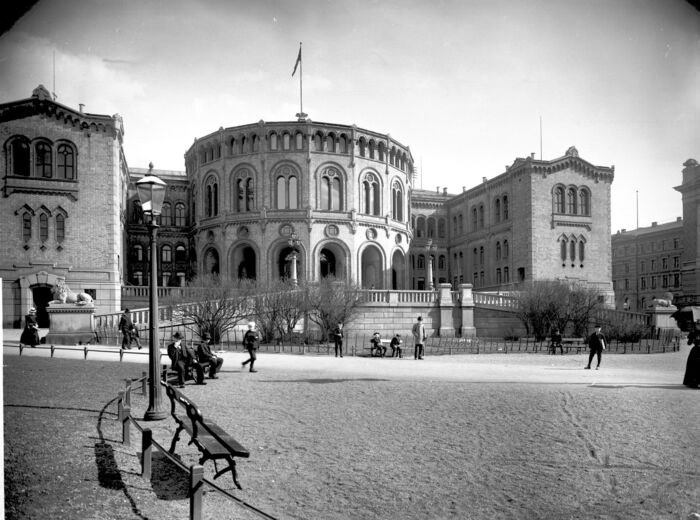 Stortinget med mennesker foran. Stort utsnitt.