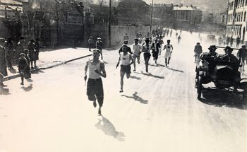 Østkantstafetten var en del av AIFs propaganda på 1920-tallet. Stafetten åpnet propagandadagene hvert år og gikk fra Dælenengen til Jordal idrettsplass. Dette bildet er tatt i Kjølberggaten på Kampen med Adelsten Haugen og Oscar Olsen i tet. Eier: Arbeiderbevegelsens arkiv og bibliotek.
