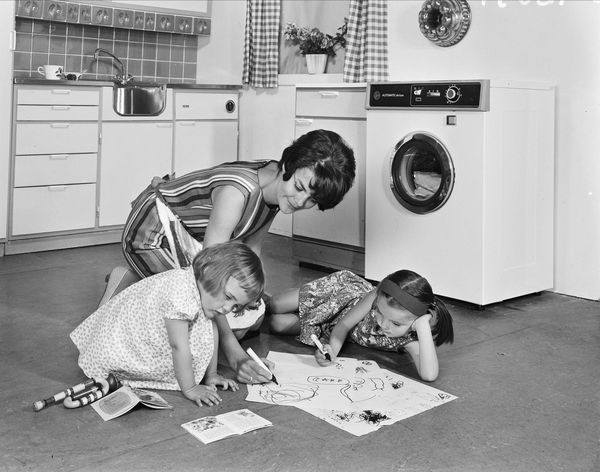 Aktiviteter på kjøkken. Bak til høyre står en Hoover-vaskemaskin. Foto: Atelier Rude. Eier: Oslo Museum.