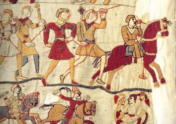 Detalj fra Bayeux-teppet, et over 70 meter langt og 0,5 meter bredt veggteppe fra omkring 1070. Teppet er utsmykket med broderier som forteller om Vilhelm Erobrerens invasjon av England og slaget ved Hastings i 1066. Dette utsnittet er hentet fra den siste scenen i teppes fortelling og viser hvordan de beseirede engelskmennene blir drevet på flukt. Teppet er bestilt av den seirende part og kan sees på som en slags tegneserie med propagandaformål: her skal Vilhelm Erobobrerens seier og invasjon huskes, minnes og feires både i samtid og ettertid. Foto: LadyOfHats via Wikimedia Commons/CC pdm
